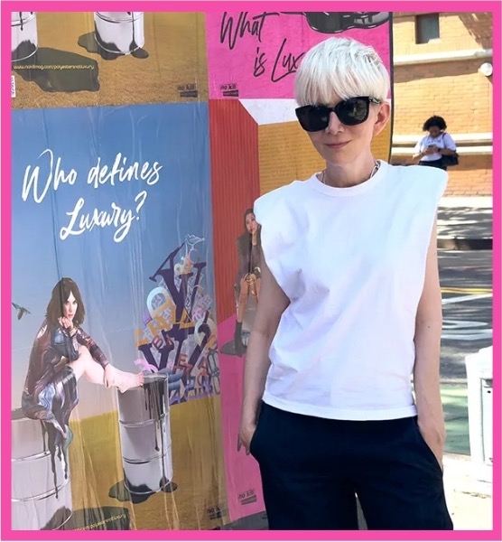 Katya Moorman standing in front of a luxury campaign poster wall