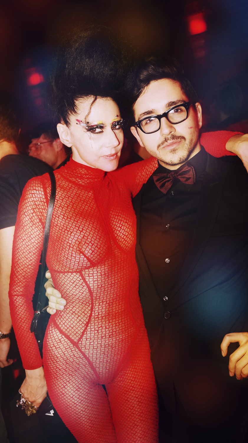Two nightlife figures posing together in red and black
