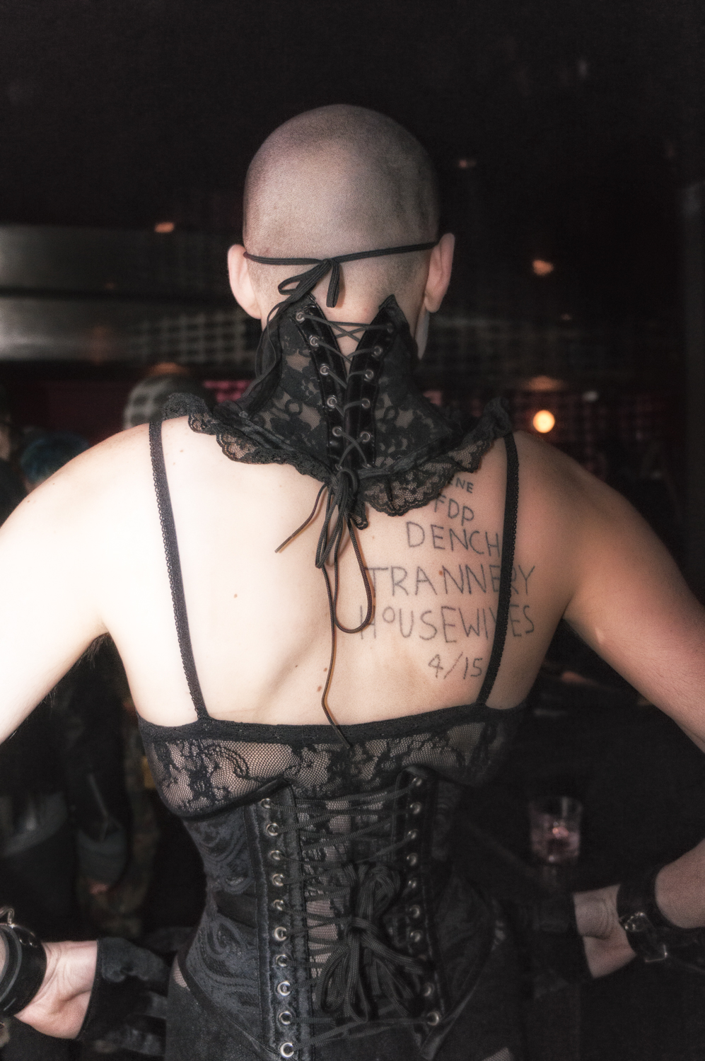 A clubgoer photographed from behind in a black lace corset