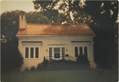 A sunlit house surrounded by trees